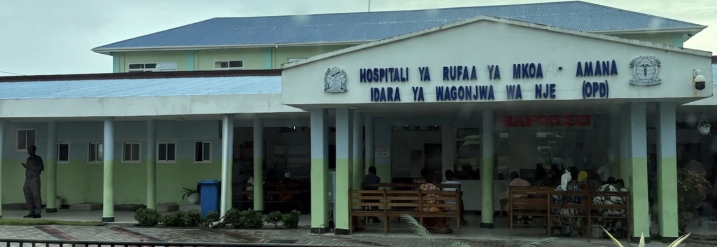 The front of a two-story hospital painted green and blue.