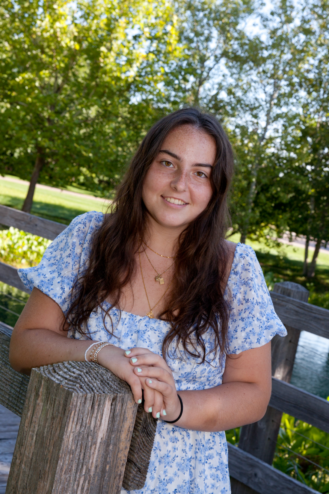 Photo of Samira Lababidi smiling while leaning on a wooden post