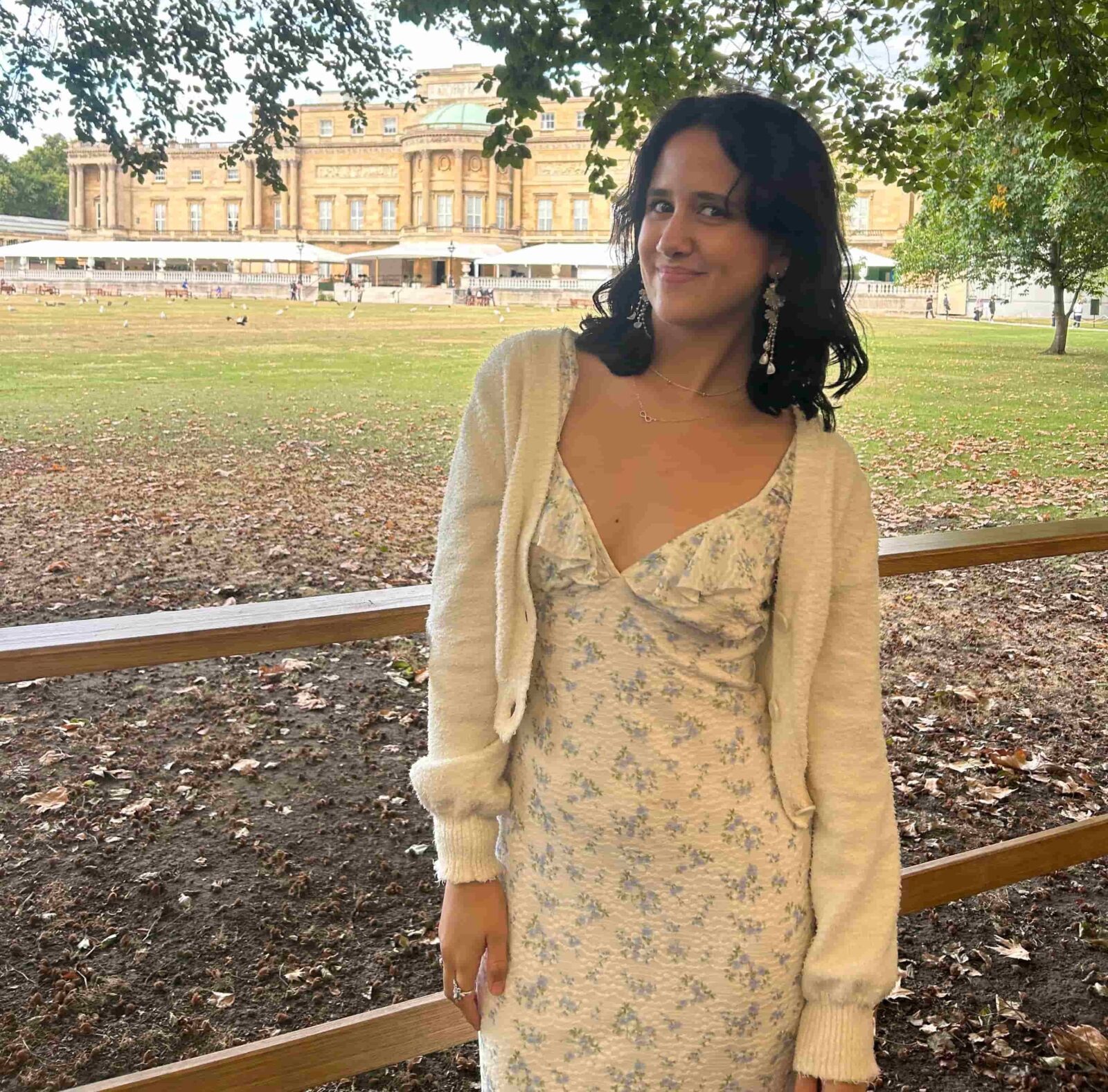 Iris smiling in front of the Buckingham Palace Gardens