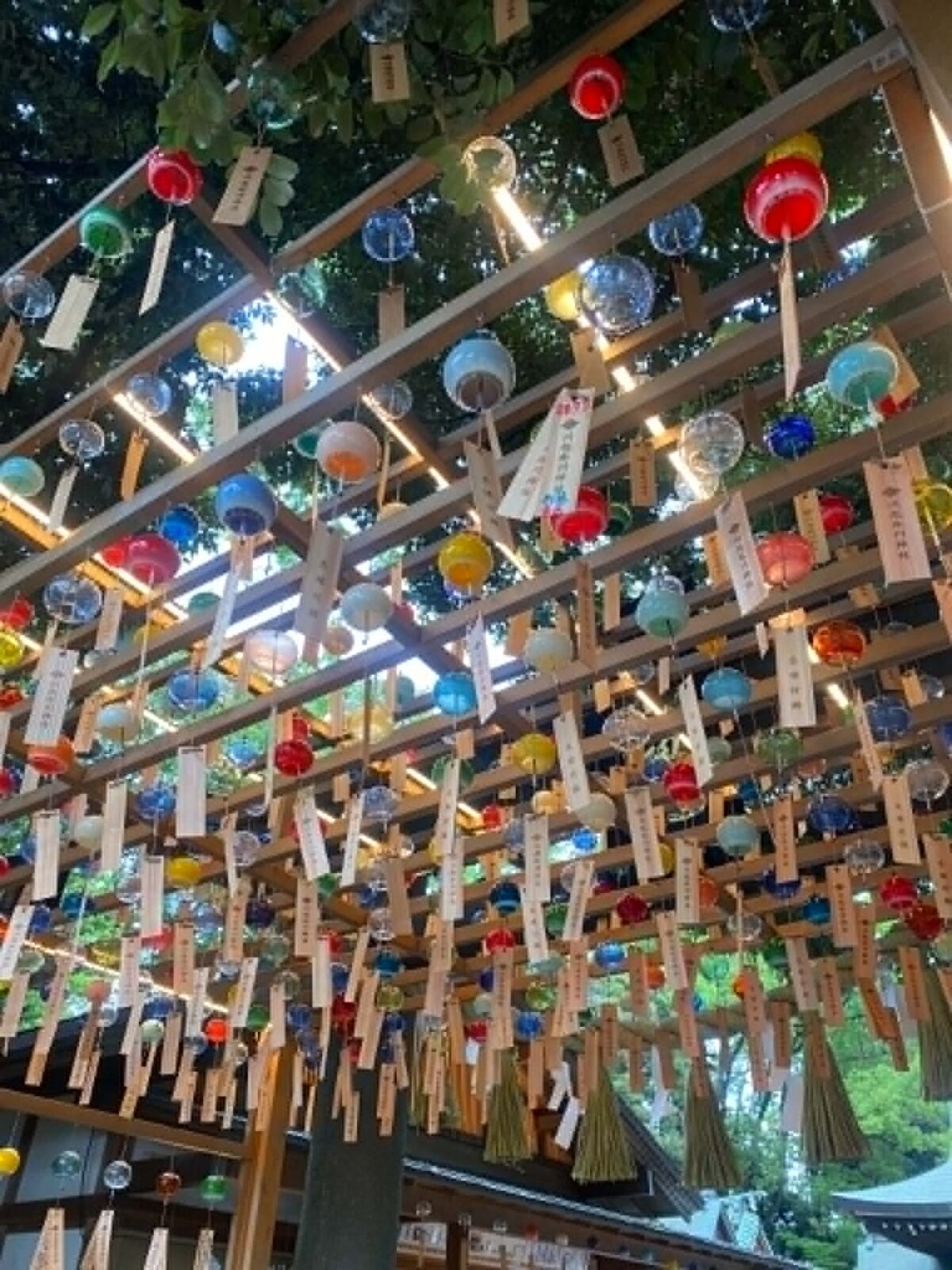 Colorful lanterns and banners hanging down from a wood-latticed ceiling.