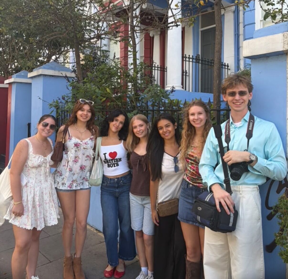 The Global Launch cohort smiling in front of a blue and white home