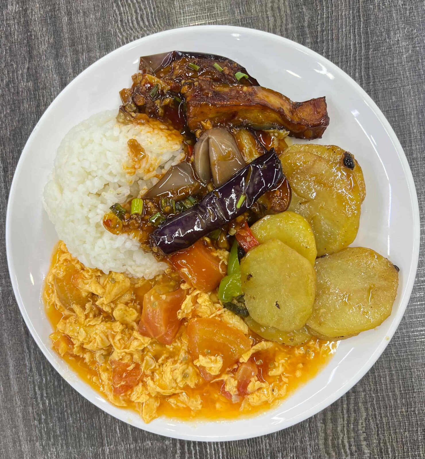 A plate of food with potatoes, rice, chicken, and vegetables.